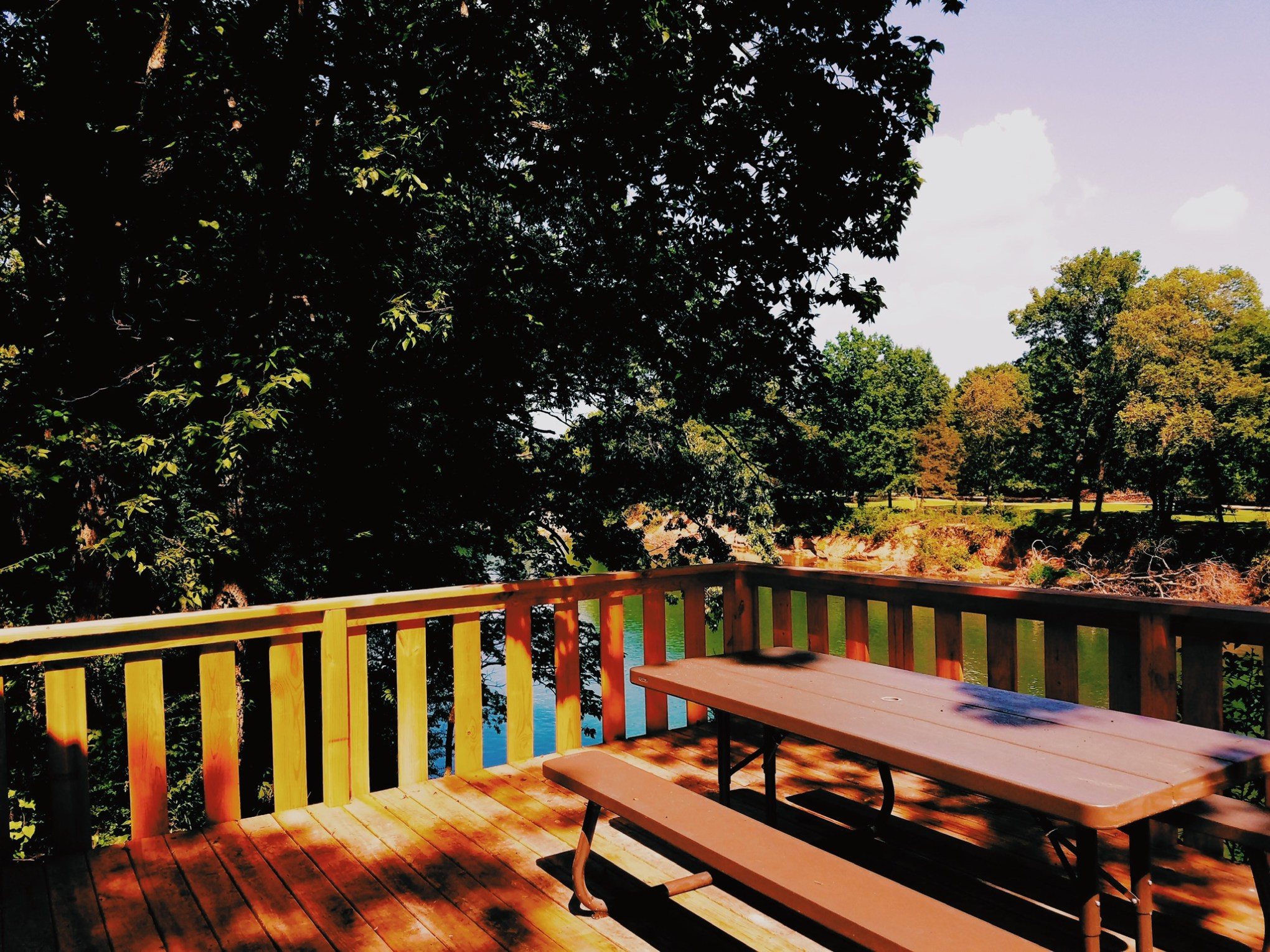 a wooden park bench sitting in front of a fence