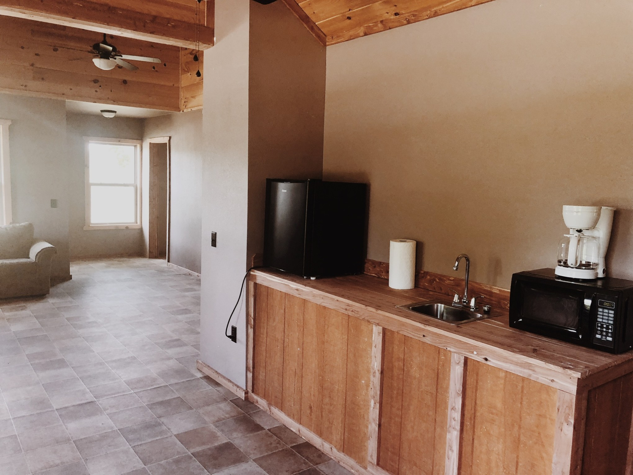 a kitchen with a sink and a mirror in a room