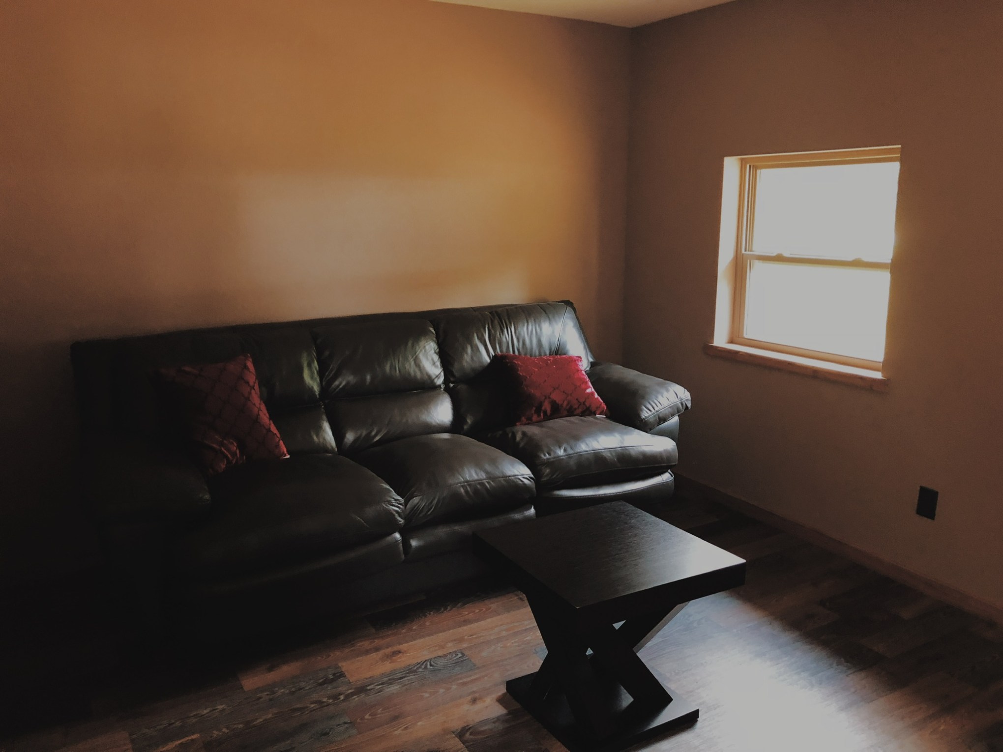 a living room with black leather couch