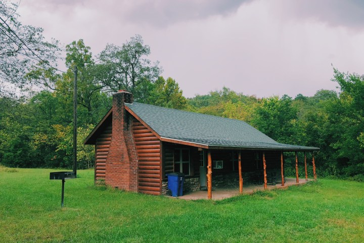 a house in the middle of a lush green field