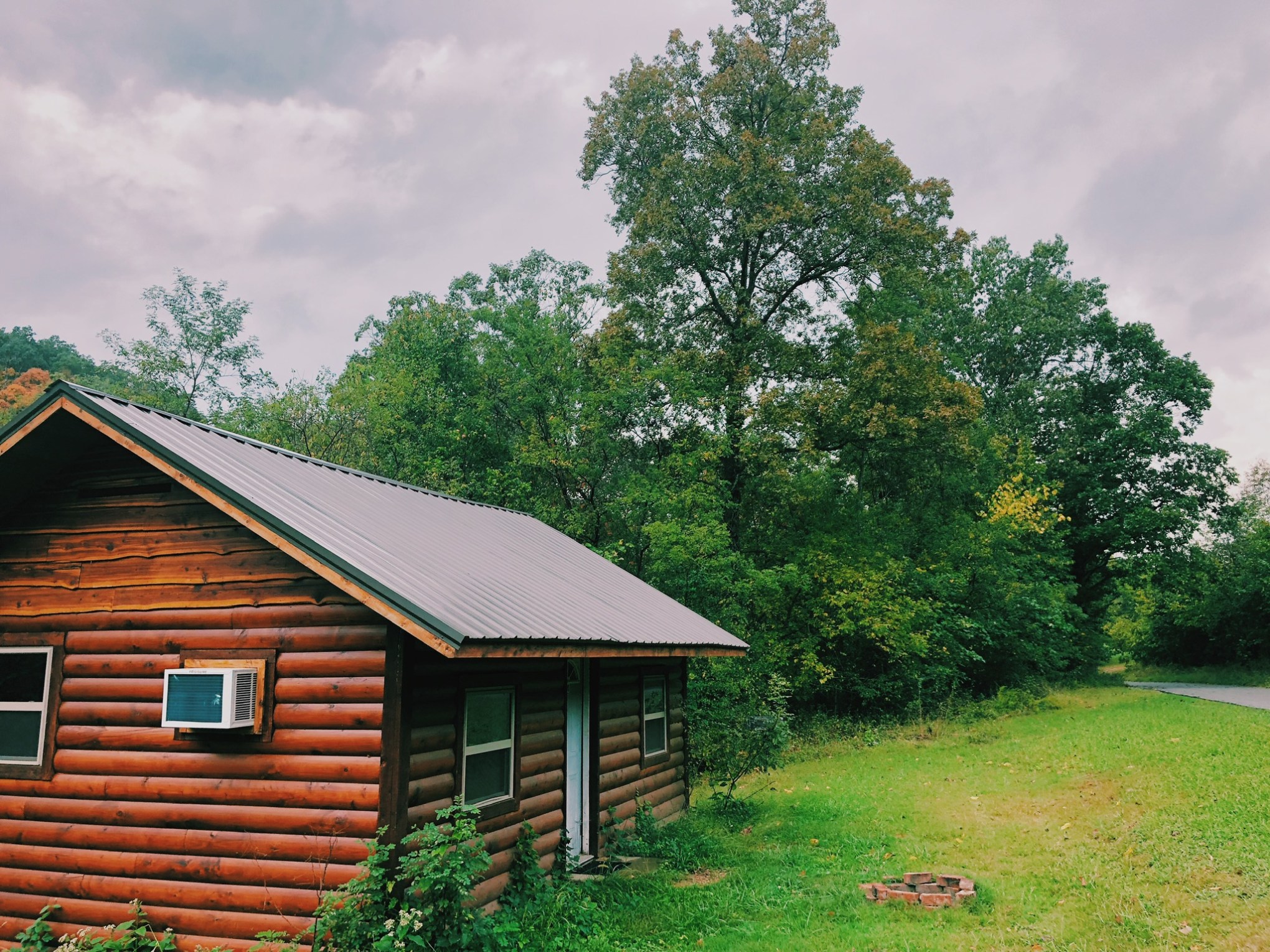 a large brick building with grass in front of a house