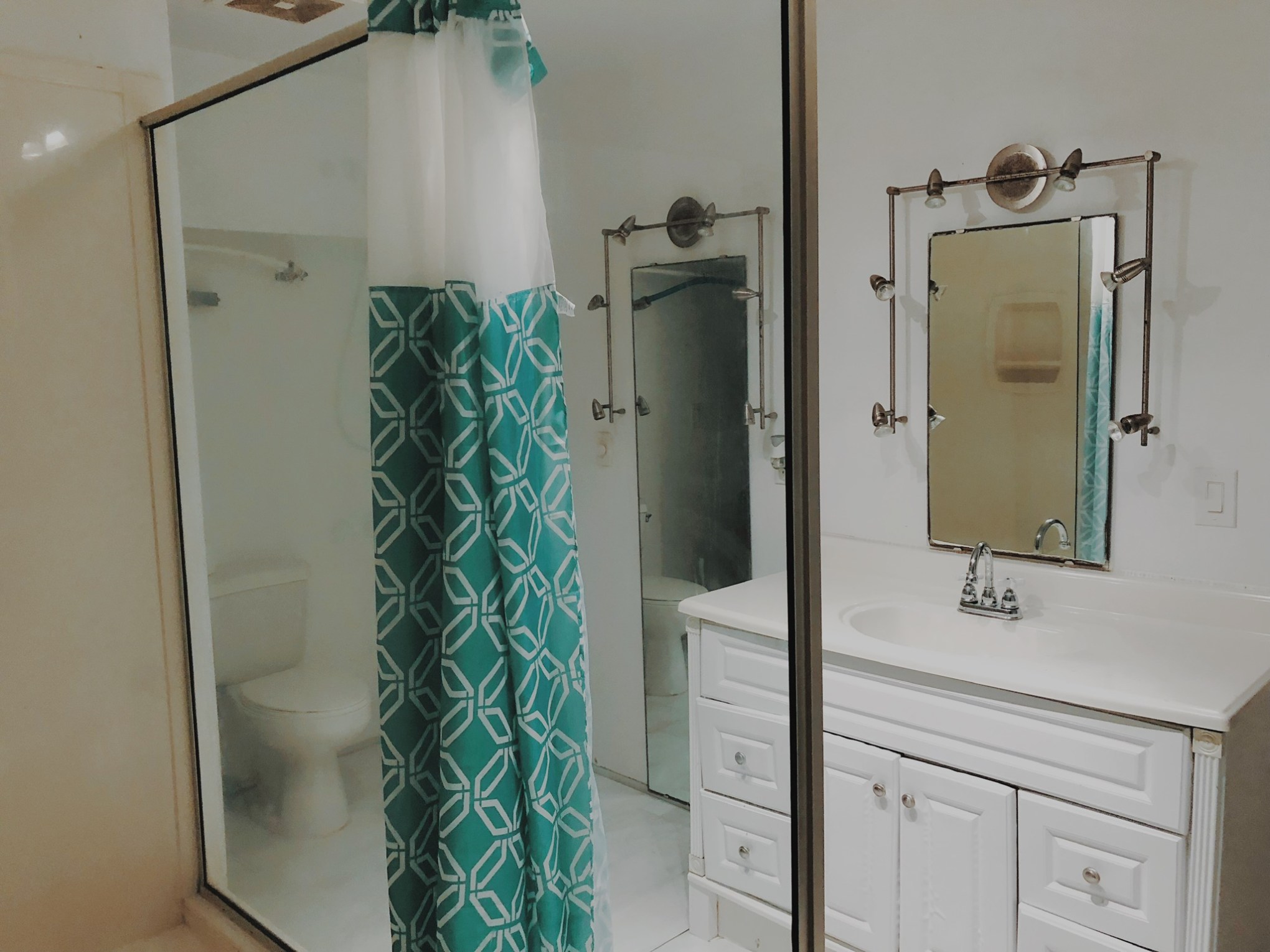 a white sink sitting next to a shower