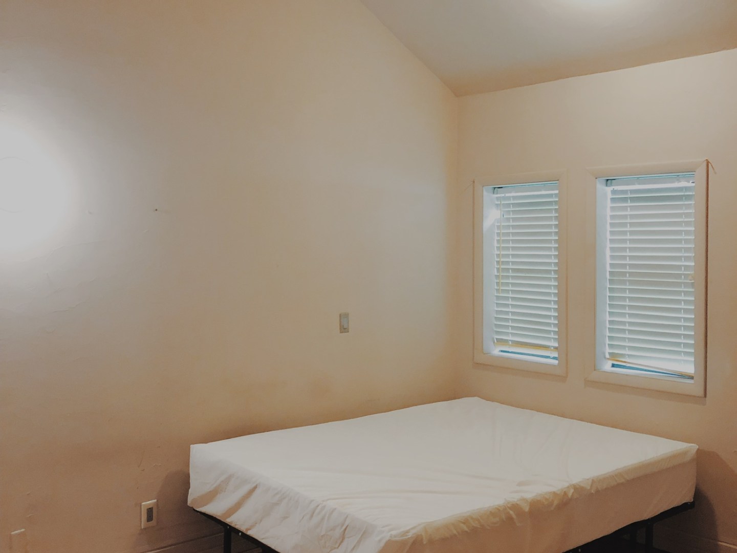 a bedroom with a bed and desk in a room