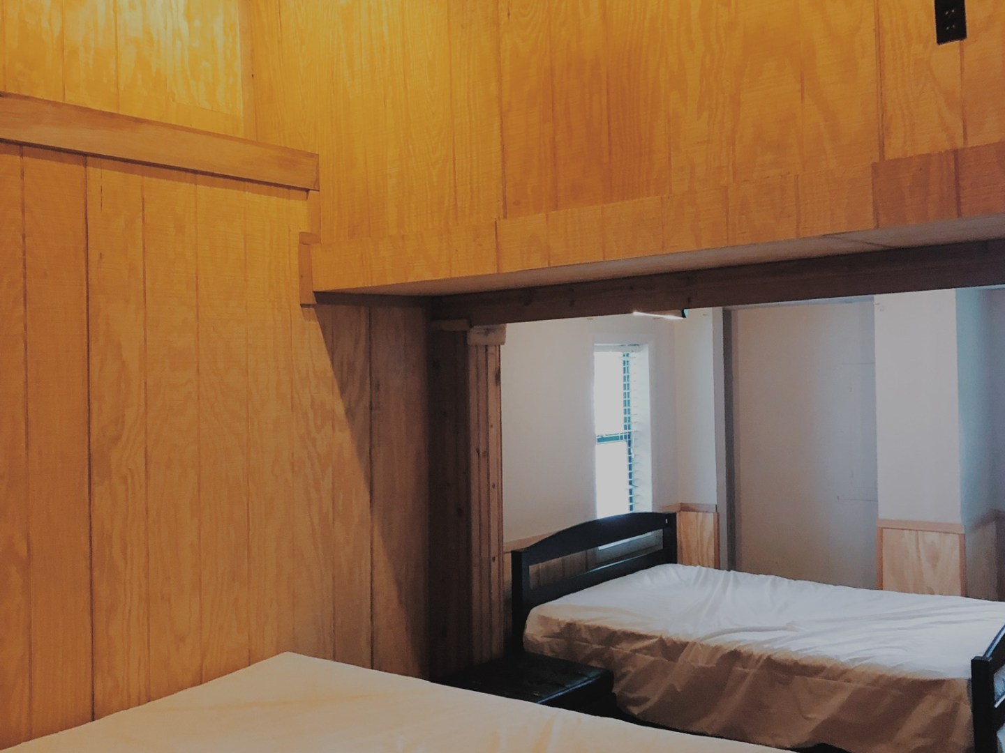 a kitchen with wooden cabinets and a bed