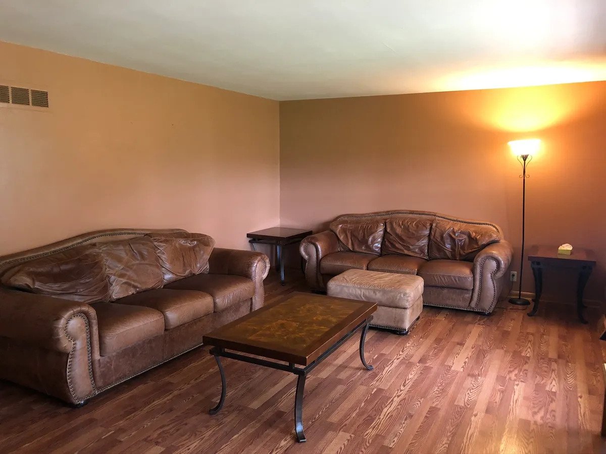a living room filled with furniture on top of a wooden floor