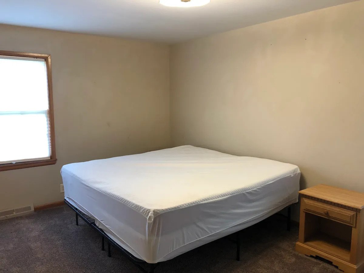 a bedroom with a bed and desk in a small room