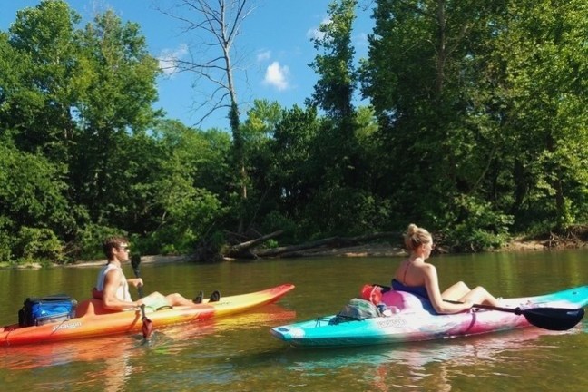 a group of people riding on the back of a boat in the water